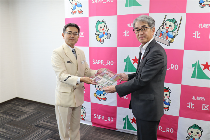 長谷川駅長から記念入場券を受け取る佐藤区長