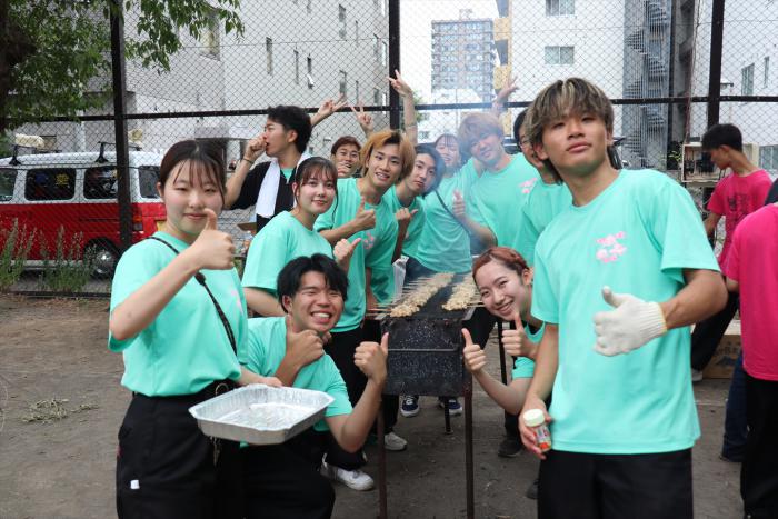 焼き鳥を焼く学生