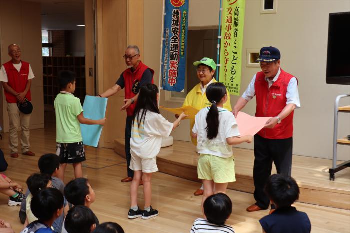 隊員にメッセージを渡す子どもたち
