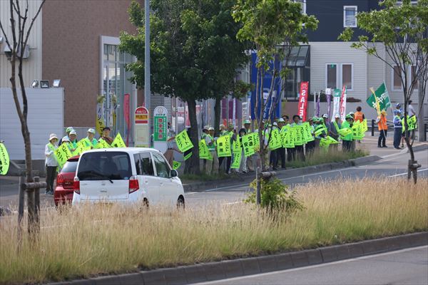 黄色い手旗を手に交通安全を訴える人波の様子