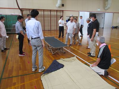 簡易ベッドを組み立て、寝袋を広げる様子