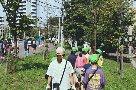 旧道沿いのごみを探す児童