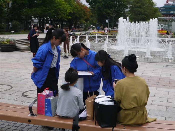大通公園の噴水の前でアンケートをとる子ども議員の写真
