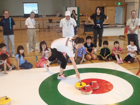 講師がカーリングを実演している様子