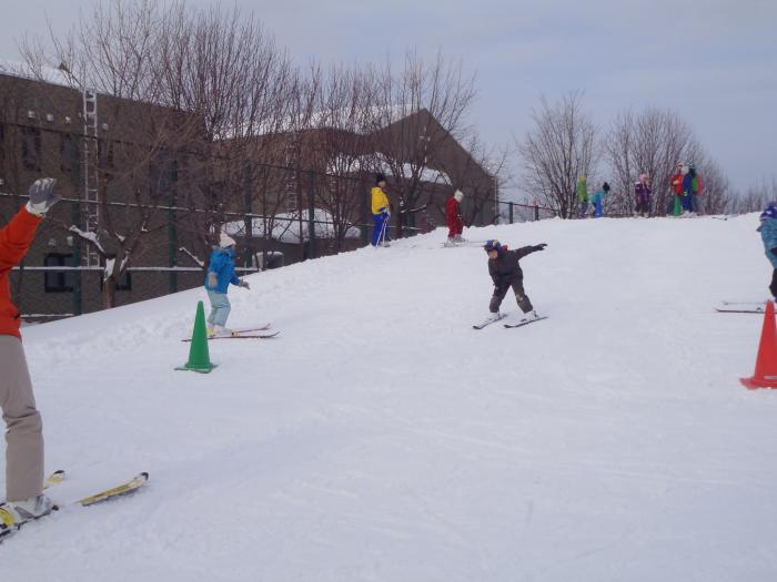 子どもが雪山を滑っている様子