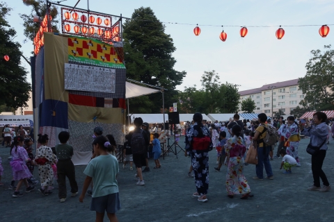 やぐらを囲んで盆踊りをする様子
