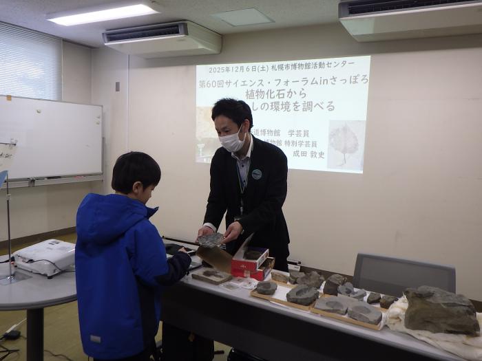 植物化石を見ながら説明をする成田学芸員