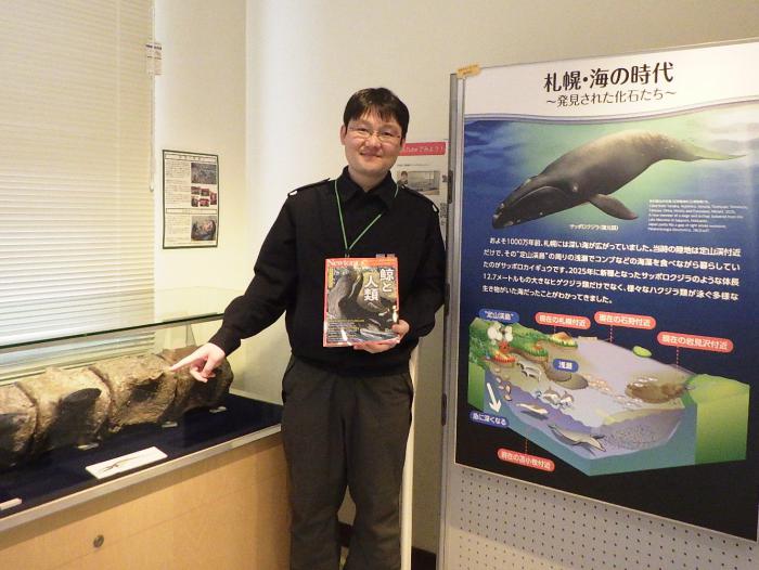 監修したニュートン別冊を手に持った田中学芸員