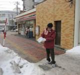 写真：店舗前の歩道の砂まき