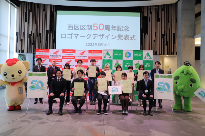 西区区制50周年記念ロゴマーク制作に携わった北海道科学大学プロジェクトチームと西区の記念写真