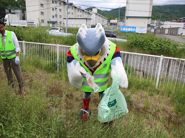 写真：マスコットキャラクターのドーレくんがごみを拾っている様子