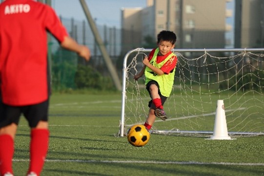 子供がサッカーボールを蹴っている写真