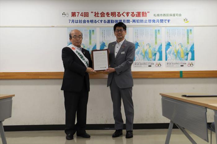 手交の様子（左：福井会長、右：村上西区長）
