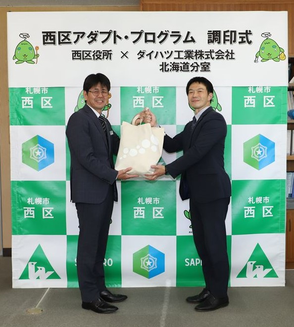 清掃用品贈呈の様子（左：村上西区長、右：板倉分室長）