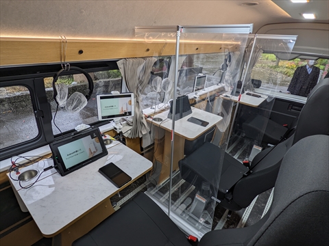 「スマサポ号」の車内、３人分の座席があり、座席ごとにテーブルとタブレットが備え付けられています