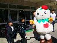 しろっぴーとハイタッチをする児童