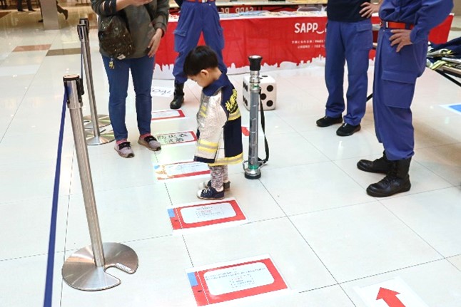 防火衣を試着する子どもの写真