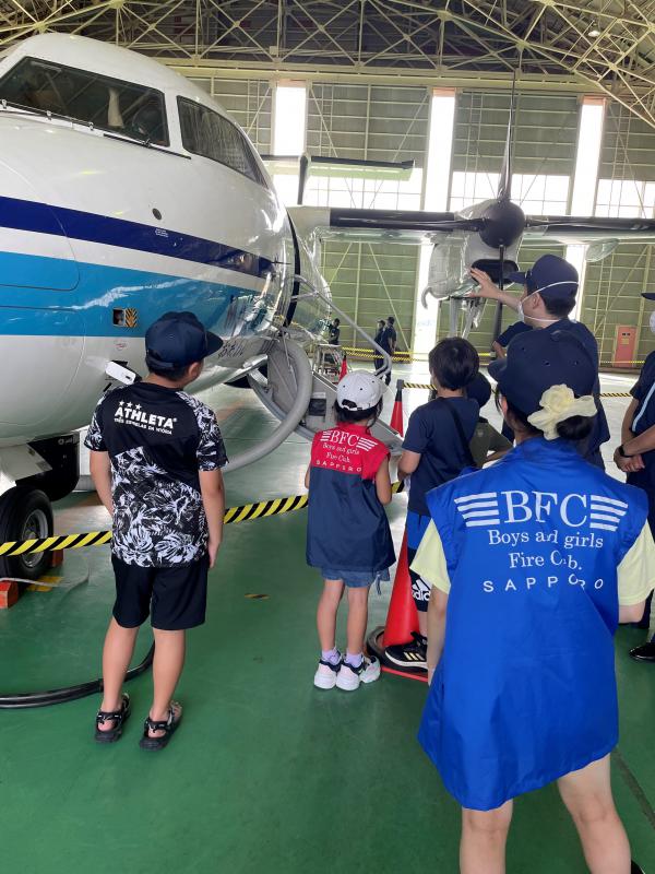 子どもたちが海上保安庁の飛行機について説明を受ける写真