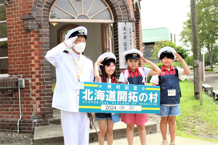 北海道開拓の村内の交番前で記念撮影をしている様子