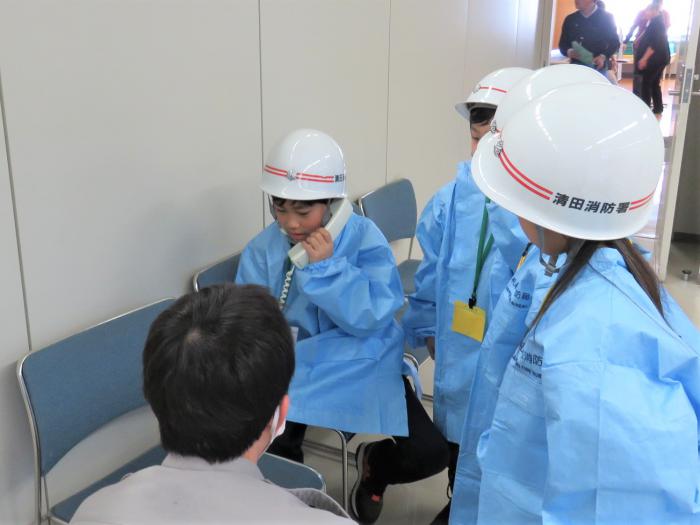 子どもが内線電話を使い、受け入れ可能な病院へ電話をしている様子