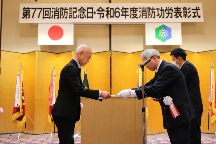 札幌国際大学付属認定こども園幼年消防クラブの園長が表彰状を授与される様子