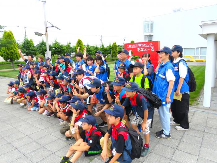施設外観を背景とした集合写真
