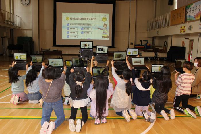 児童みんなでタブレットを見ている様子