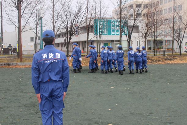 指揮者の指示により息を合わせて行進する北野分団員