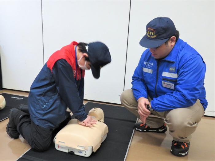 クラブ員が胸骨圧迫の実技試験を受けている様子