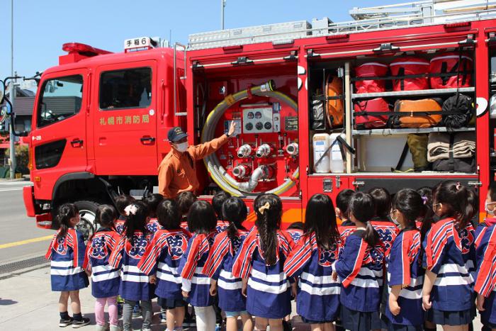 消防車両の説明を園児が聞いている様子