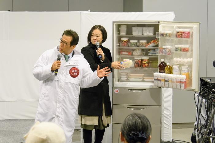 冷蔵庫の前で語り合う広沢さんと秋元市長