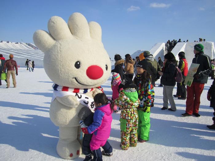 雪まつりの、つどーむ会場の屋外の雪の上で、子供たちと触れ合う、ていぬの画像