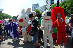 よさこいソーラン祭りで、多くのキャラクターや参加者と、ワオドリをする、ていぬの様子を写した画像