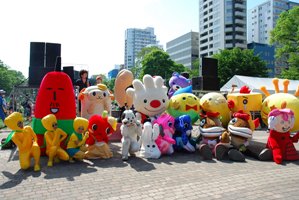 よさこいソーラン祭りで、多くのキャラクターや参加者と、記念撮影をする、ていぬの様子を写した画像