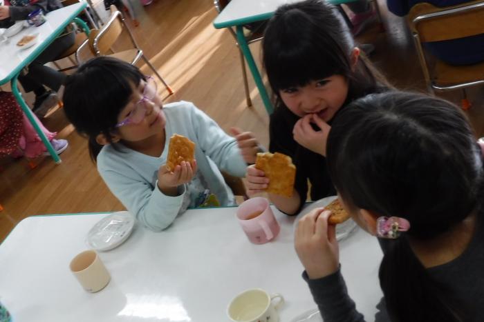 3人で、ていぬせんべいを食べる子供の画像