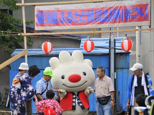 軽川盆踊りの会場で、法被を着て子供と触れ合う様子の、ていぬの画像