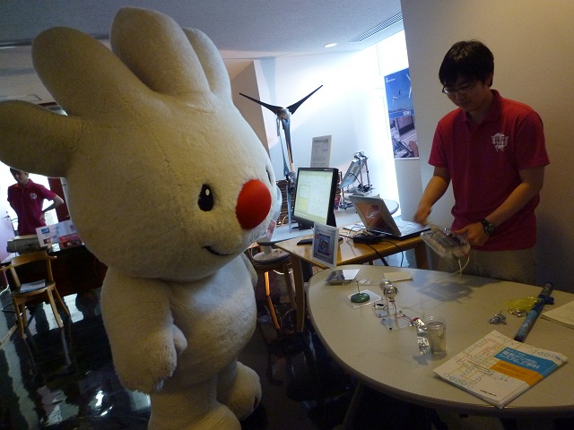 北海道工業大学のオープンキャンパスで、学生の実験を見学する、ていぬの画像
