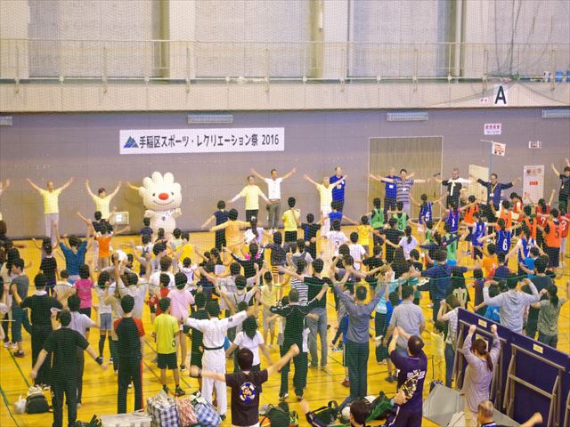 スポーツレクリエーション祭の会場で、参加者と一緒に、ラジオ体操をする、ていぬの様子を写した画像