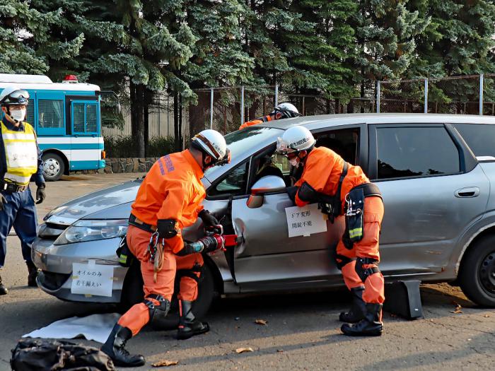 乗用車のドアを開放して負傷者を救助する様子