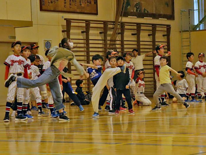 遠くへボールを投げる子どもたち