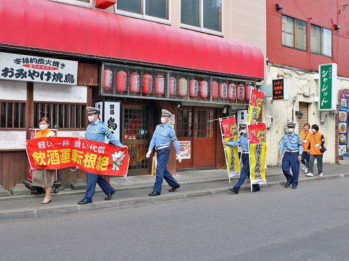 横断幕と旗を掲げながら移動する一行