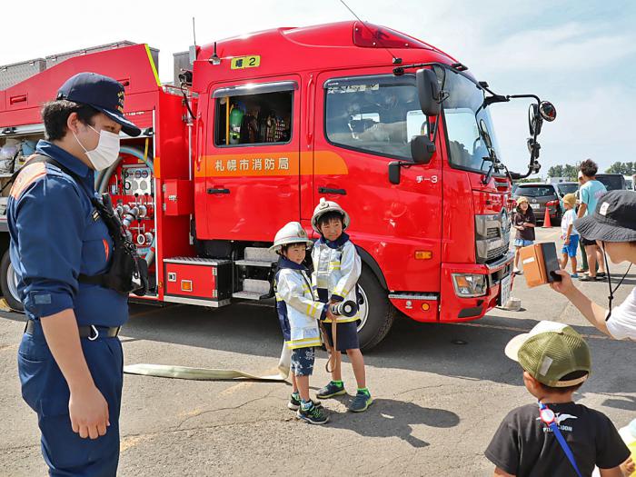 防火服を着て記念撮影をする子どもたち