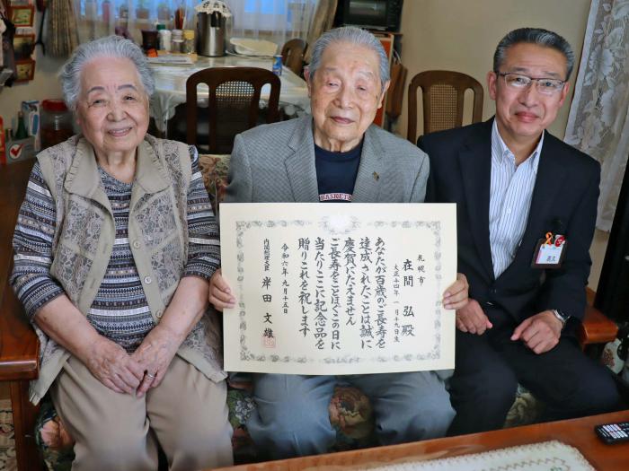左から妻の幸子さん、在間さん、高久区長