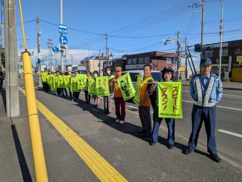 「スピードダウン」と書かれた旗を手に掲げるみなさん