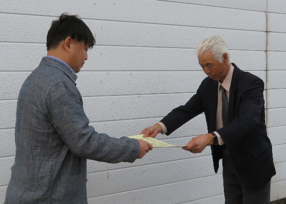 区職員から表彰状を伝達される佐藤さん