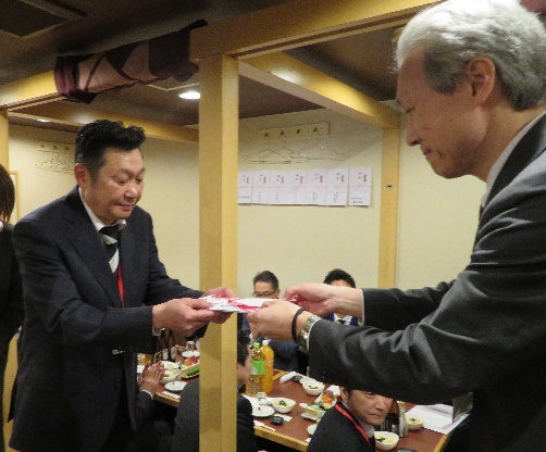 豊嶋会長から里区長に寄付が贈呈される