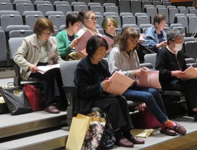 資料を読みながら審議に参加する人々