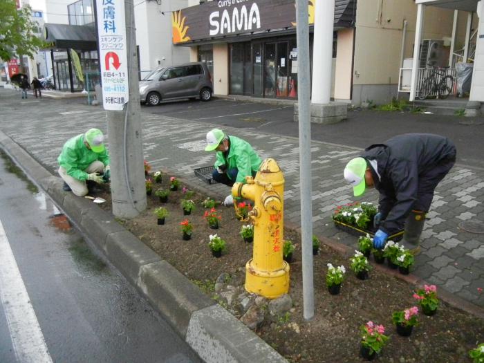 丁寧に花を植えている写真