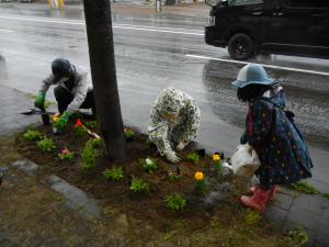子どもが花に水をあげている写真