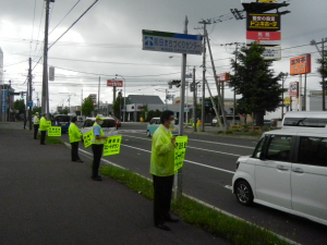 自動車の運転手にスピードダウンを呼びかけている写真